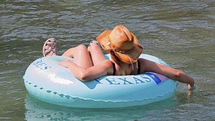 A Lone Star tuber drifts along the Comal River in New Braunfels.