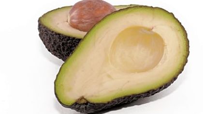 Avocado cut in half, with its stone/seed exposed.
