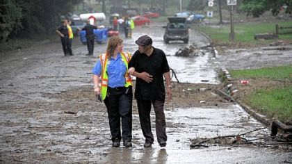 Paramedic Stacey Yaras, crew chief for Medic 14, walks Rhodearland "Bob" Bailey, 79, of Penn Hills away from the scene of a flash flood along Washington Boulevard at Allegheny River Boulevard on Friday. Mr. Bailey said he was on Washington Boulevard in his Oldsmobile Bravada when water began rising around the vehicle. He climbed out of a car window and stood on the roof -- water reaching up to his ankles -- before being rescued by boat.