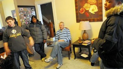 From left, Benjamin Payne, Lamar Woodward, 14, and Derrick Smith visit Gary Agate at his Pitcairn home. The boys live on the same street where Gary and his wife, Carol, recently moved.