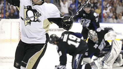 The Penguins' Tyler Kennedy shoots against Red Wings goalie Jimmy Howard, and defenseman Jakub Kindi to score in the second period Monday in Detroit.