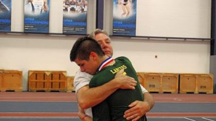 Deer Lakes assistant coach Terry Gaston hugs his son, Jeremy, a current player for the Lancers after Deer Lakes won the PIAA Class AA title Saturday at Penn State University.