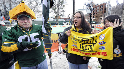 Packers fan Scott Biemeret tries to convince Steelers fans Angelina McKlveen and Jona Domingues that the cheesehead is better than the terrible towel in Fort Worth Thursday.