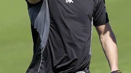 Evan Meek jokes with teammates after being offered a Pirates cap to replace a camouflage-print cap he had been wearing at a voluntary spring training workout Sunday.