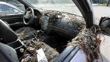 Cars caught in flash flooding on Washington Boulevard are covered with mud and debris.