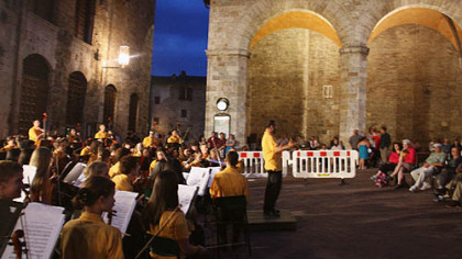 Pittsburgh Youth Symphony Orchestra conductor Lawrence Loh gives his opening remarks at the start of the group's San Gimignano concert in the town's main square.