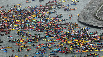 People in canoes and kayaks paddle in to join together during  an attempt to break the world record for a joined flotilla off the Point at Pittsburgh on June 5, 2010.