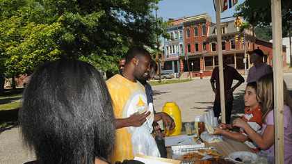 Protesters set up a lemonade stand in Allegheny Commons on the North Side to protest tax loopholes for large corporations such as General Electric and Exxon Mobil. They claimed to be selling "$10,000 lemonade" to make up the shortfall in the Pittsburgh Public Schools budget. Actually they were giving it away to raise awareness. "Prez" Johnson, center, gets a cup of lemonade and talks with Ricky Torres, 10, second from right, and his cousin Allie Wingold, also 10, far right, who were staffing the stand.