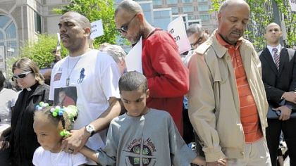 The Rev. Glenn Grayson, second from left, whose son Jeron Grayson was shot and killed while home from college in October, leads the final prayer at a demonstration against gun violence held across the street from the David L. Lawrence Convention Center during the National Rifle Association's national convention Saturday. Standing with him are Jeron's niece Aniyah Grayson, 5, Elisha Blackwell, 8, and the Rev. Lee Walls, second from right.