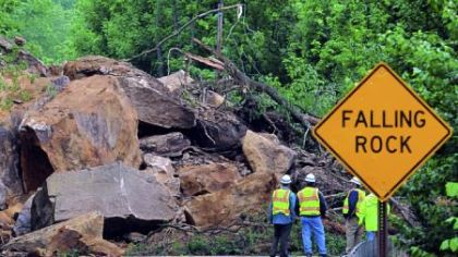 PennDOT officials are dwarfed by the boulders that landed on Route 88 in East Bethlehem, Washington County. PennDOT District 12 executive  Joe Szczur said rock is still hanging about 80 feet above the road.