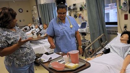 Robin Campbell, left, a registered nurse, helps Brazil Scott, 17, of Peabody High School, check vital signs of a mannequin at the STAR Center at the West Penn School of Nursing.