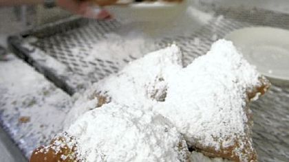 A waitress puts powdered suger on plates of beignets at Cafe Du Monde.