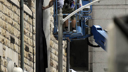 A black cloth is rigged to control light Trinity Cathedral as "The Dark Knight Rises" films in Downtown Pittsburgh Aug. 10.