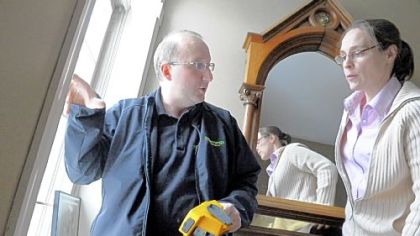 Constantine Paliouras points to air flow from window seams in the home.
