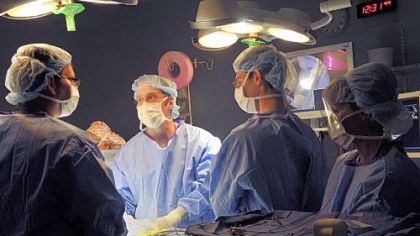 Dr. David C. Streitman, center, a fetal surgeon and an associate of Dr. Stephen Emery, fetal surgeon, right, checks the insertion of operating instruments for laser surgery done to the placenta of Rachel Lendyak-Peters, which is being shared by her identical twins.