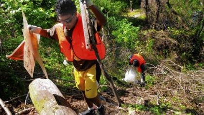 Ali Nafees, 15, of the Republic of Maldives carries discarded items. Behind him, Mohamed Sadique, 15, of Sri Lanka puts trash into a plastic bag. StashTheTrash.org conducted a cleanup in Bloomfield with students participating in Magee Womancare International South Asia Youth Summit.