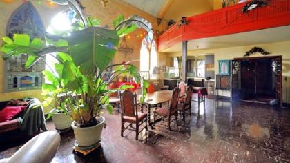 The former sanctuary is now a large open living space, with the kitchen tucked into a corner under the former choir loft.