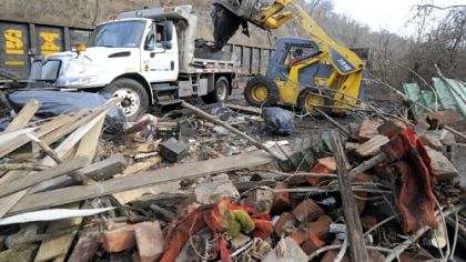 Odell Minniefield of Jadell Minniefield Construction Services loads a city dump truck with trash collected from illegal dump sites along the Monongahela River.