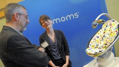 Emily Cappo of 4moms promotes the company's mamaRoo rocking device to Philip Yeske, president and CEO of Fluorous Technologies, at the IBEW Hall on the South Side. 4moms was among 15 companies seeking investors during the daylong event.