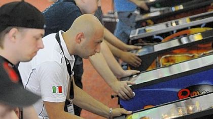 Daniele Acciari, dressed in the white shirt, 26, of Rome, Italy, and others compete Thursday in the pinball championships in Scott.