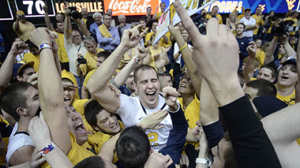 West Virginia's Cam Thoroughman, center, celebrates with fans following a 72-70 win against Louisville today in Morgantown, W.Va.