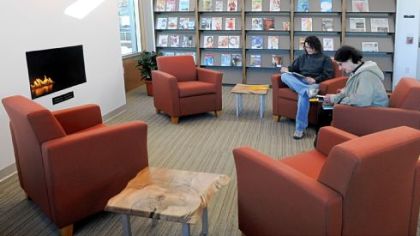 Ruth Bogdan, left, and her mother, Ruth Collura, sit in the reading area around the fireplace in the new, $2.5 million Bridgeville library. They were the first in the door when it opened Monday.