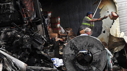 Workers remove freight from the wrecked tractor-trailers.
