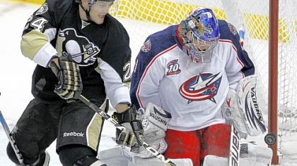 Matt Cooke, left, attempts to backhand a rebound off Columbus Blue Jackets goalie Steve Mason Tuesday