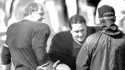 Mike Webster helps replacement player Ben Lawrence stretch before a workout in the 1987 strike camp in Johnstown.