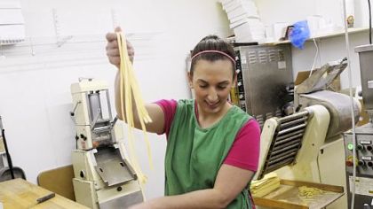 After finishing rolling and cutting the pasta, Sandy Falcione boxes freshly made fettucine at Donatelli's Italian Foods.
