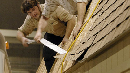 Farm Show vendors Wilmer King, left and Ben King, right, of Pine Creek Structures, tear down their two-story barn outbuilding on the floor of the exhibition hall.