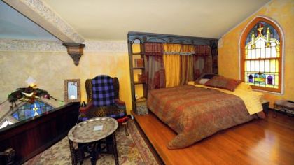 The former choir loft is now his bedroom, open to the living space below.