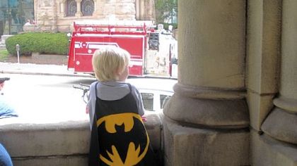 Jake Schraven, 5, in a handmade Batman cape, watches the filming.
