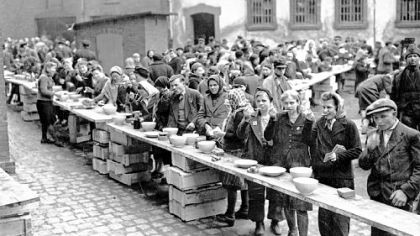 European refugees eat at a dispersal point at the former German political prison at Ansalt on March 19, 1945.