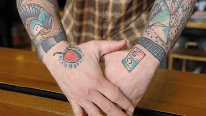 Kevin Sousa, owner and chef at Salt of the Earth restaurant in Garfield, shows his "salt and pepper" tattoos.