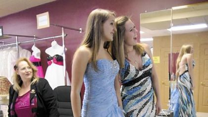 Harper's Bazaar Bridal Boutique owner March Walter watches as Emily Kinnunen, right, 18, and Lisa Cross, 17, admire potential selections at the store in Monroeville.