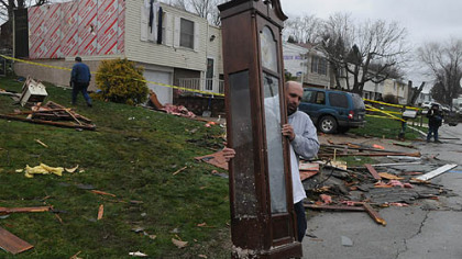Brian Steiner, of Greensburg, carries a grandfather clock from Shirley Clark's home Thursday morning on Fosterville Road in Hempfield. He said that he "saw things going through the air" from his home. The roof is gone from Ms. Clark's home.