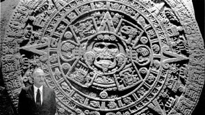 Carlos Fuentes stands next to the Aztec calendar in the National Museum of Anthropology in Mexico City.
