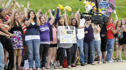 A line of people waiting to audition cheer during the filming of the show's promotional spot.