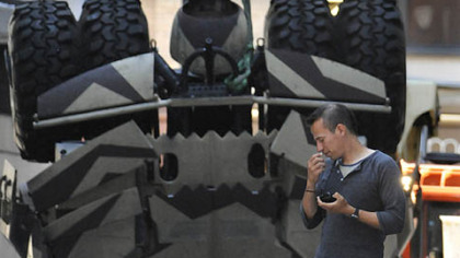 The crew of "The Dark Knight Rises" removes a Tumbler vehicle from the blast crater constructed on Cherry Way after the second take Thursday morning.