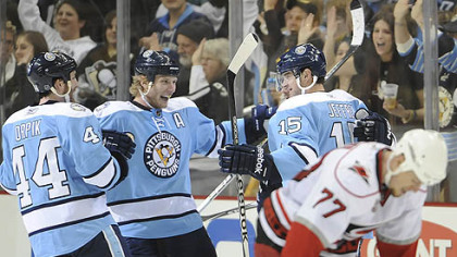 Penguins forward Dustin Jeffrey celebrates a second period goal with teammates Brooks Orpik and Jordan Staal as Hurricanes defenseman Joe Corvo looks down during Saturday's game at Consol Energy Center.