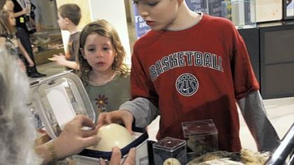Theo Wahlenmayer, right, 8, and his sister Claire, 5, of McCandless examine an ostrich egg during a program at the Carnegie Museum of Natural History on Saturday. With Easter falling today, the program was organized around the science of eggs.
