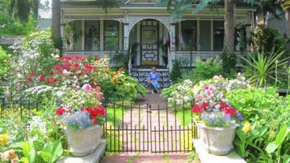 Jennifer Guercio sits on the front porch of her restored Victorian, a favorite stop on GardenWalk Buffalo.