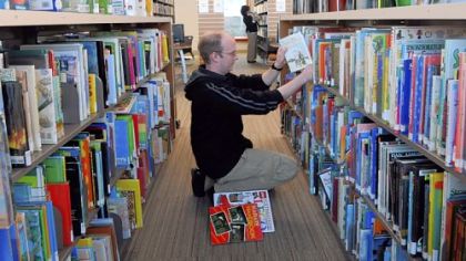 Ed Wolf, a clerk at Bridgeville Public Library, returns books to the shelves in the new, $2.5 million library, which opened Monday on McMillan Street.