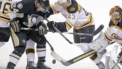 Mt. Lebanon native and Boston Bruins defenseman Matt Bartkowski, right, battles the Penguins' Matt Cooke for the puck in Monday night's game at the Consol Energy Center. Bartkowski made his NHL debut in the contest, which the Bruins won, 4-2.