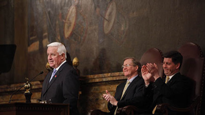 Gov. Tom Corbett talks about his 2011-2012 budget proposal before the state Legislature. Behind him are Speaker of House, Rep. Sam Smith, R-Jefferson, left, and Lt. Gov. Jim Cawley.