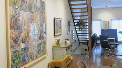 A floating staircase runs against the wall in the great room that combines the living room and dining room areas.