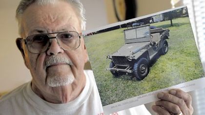 Leeland Bortmas holds a photo of his 1941 Bantam "BRC 40" military Jeep. Bortmas has organized a weekend festival in Butler honoring the vehicle.