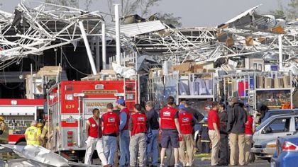 Lowe's Home Improvement employees gather in the parking lot of their store after it was destroyed by Saturday's tornado in Sanford, N.C