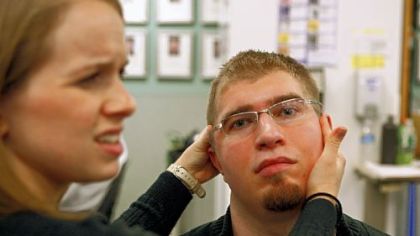 Physical therapist Stacy Potkulski reacts after Preston Plevretes complains of a headache during his physical therapy in Freehold, N.J., on Dec. 11, 2009.